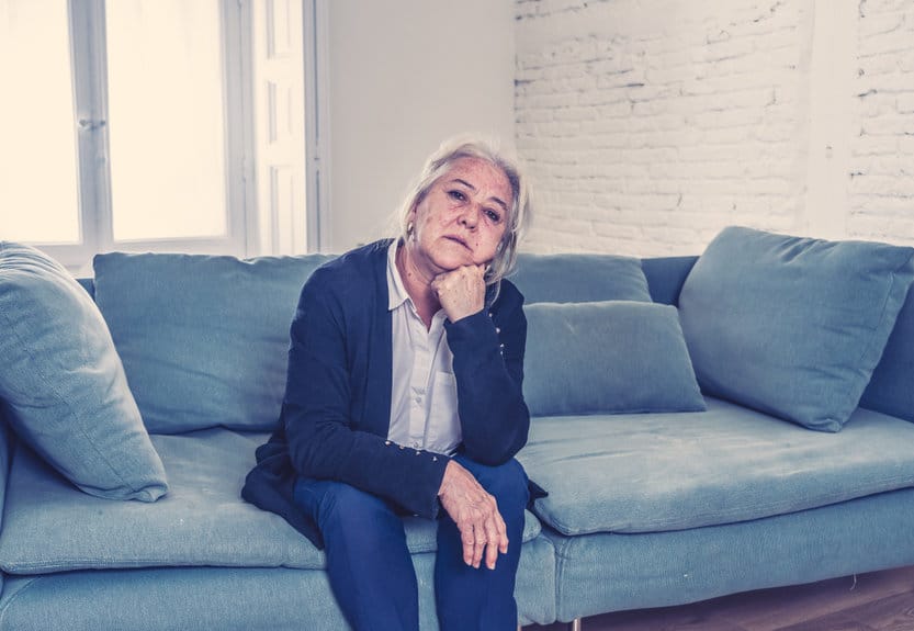 Confused elderly woman sitting on couch
