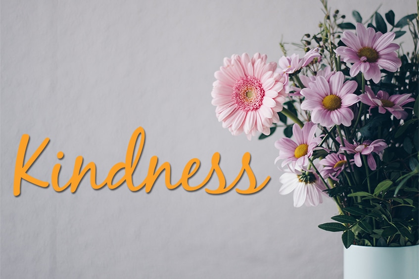 Vase of flowers with the bold word kindness
